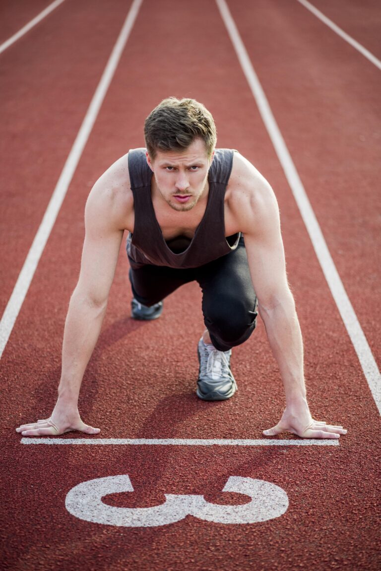 Male athlete in starting position on running track, representing fitness and health in Cyprus.