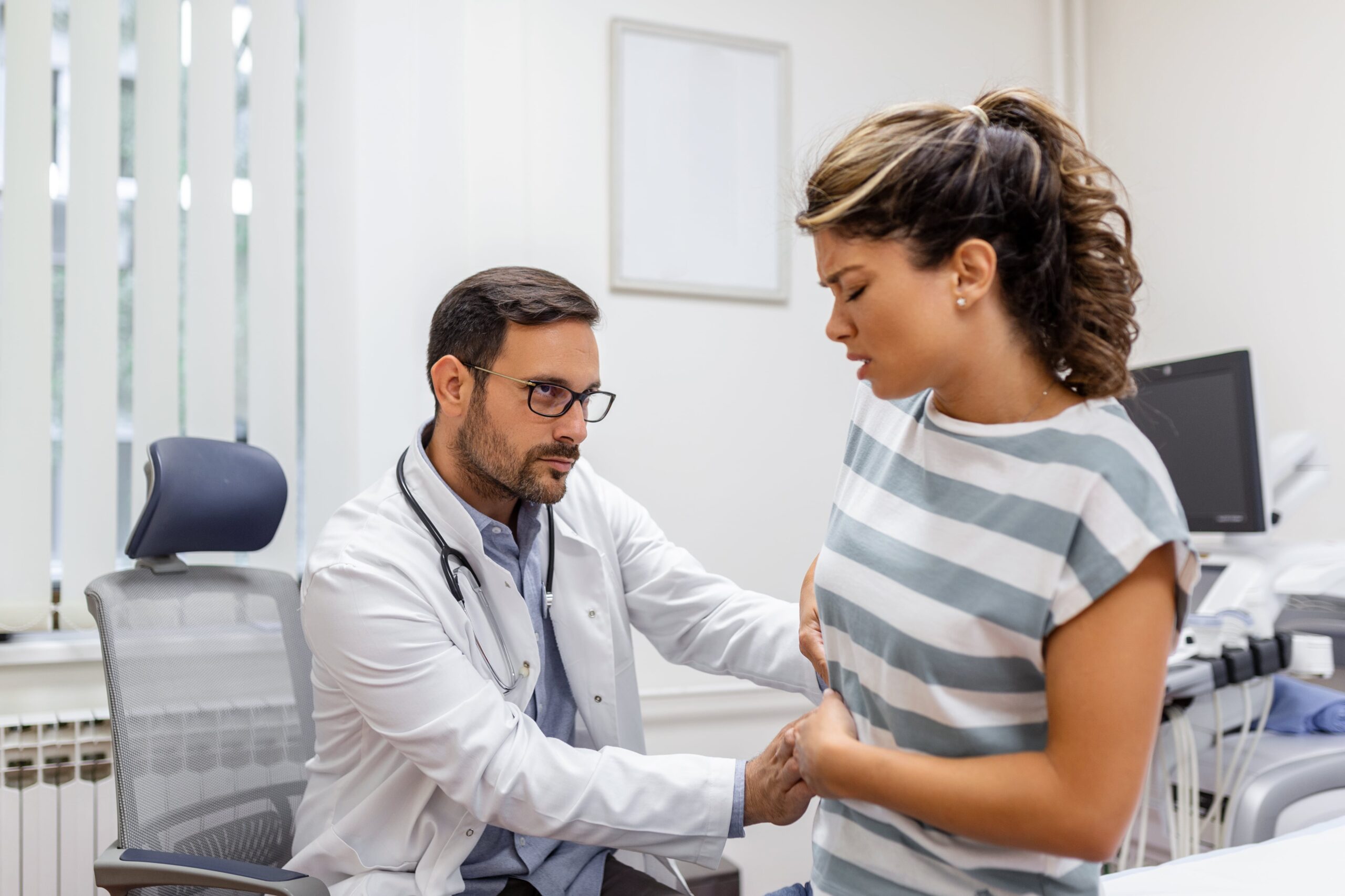 Healthcare professional consulting a fit woman in a clinic, representing personalized health care in Cyprus.
